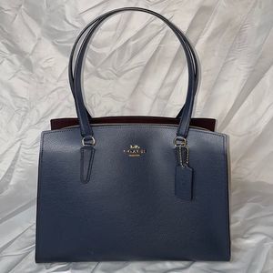 COACH carryall shoulder tote with middle zip compartment and crossbody strap.